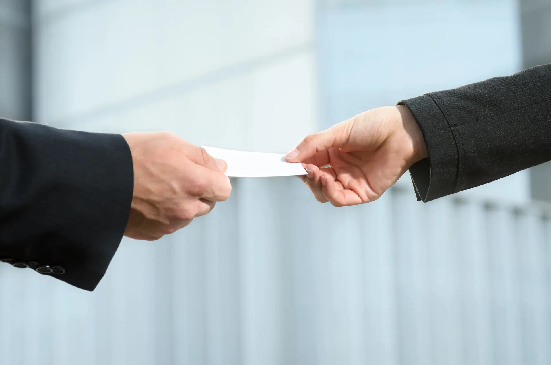 Close-up of two professionals exchanging employment documents