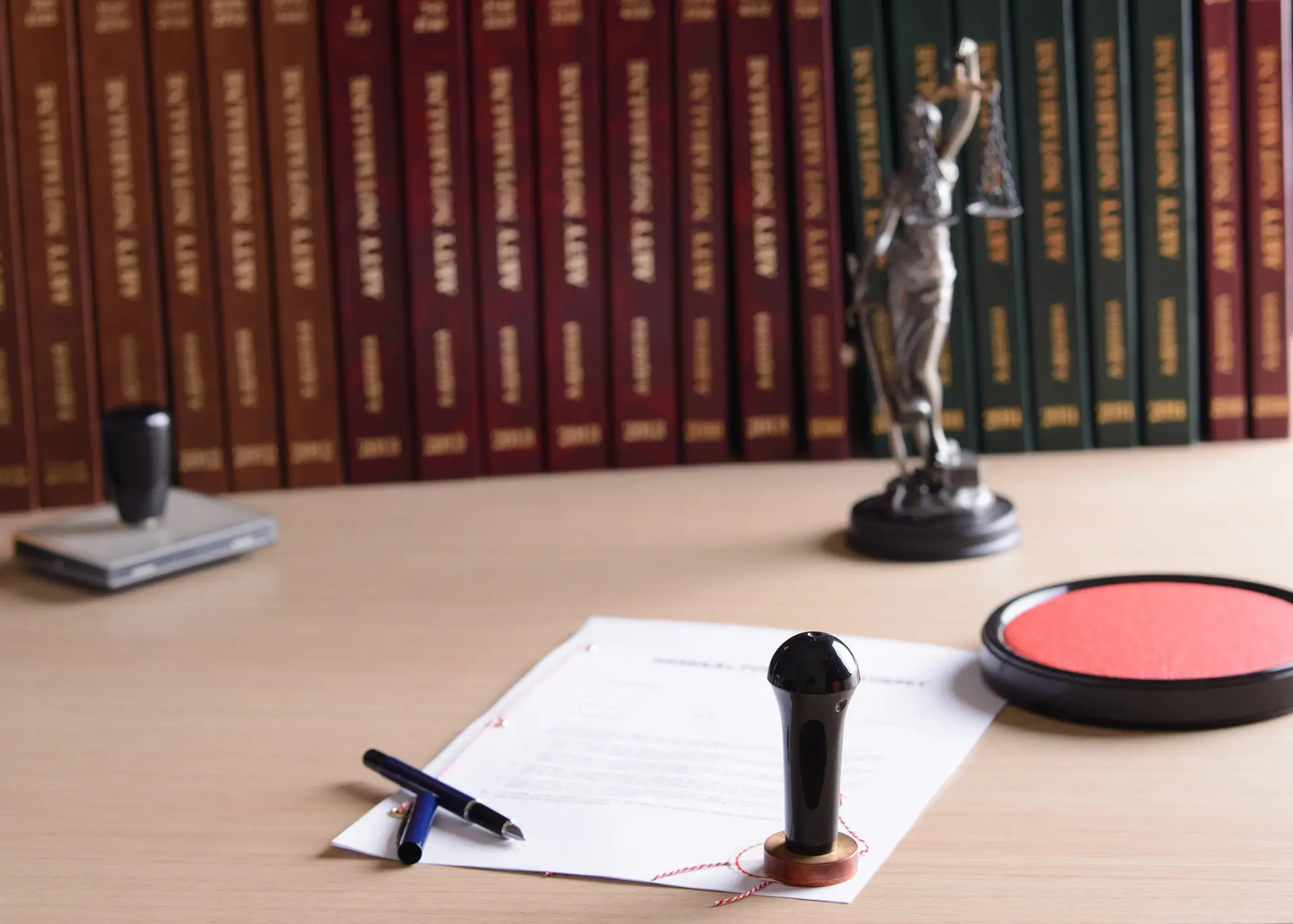 Notary seal and legal document on desk with law books in background