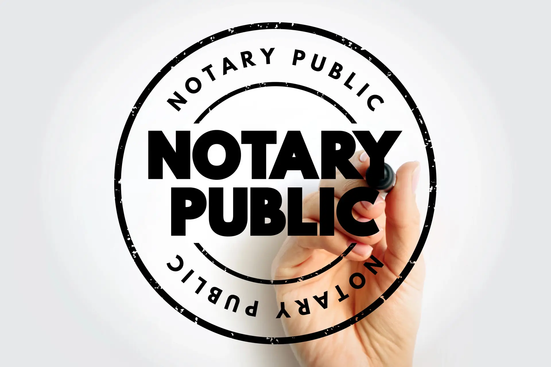 Hand holding a notary stamp over a bold black and white notary public emblem