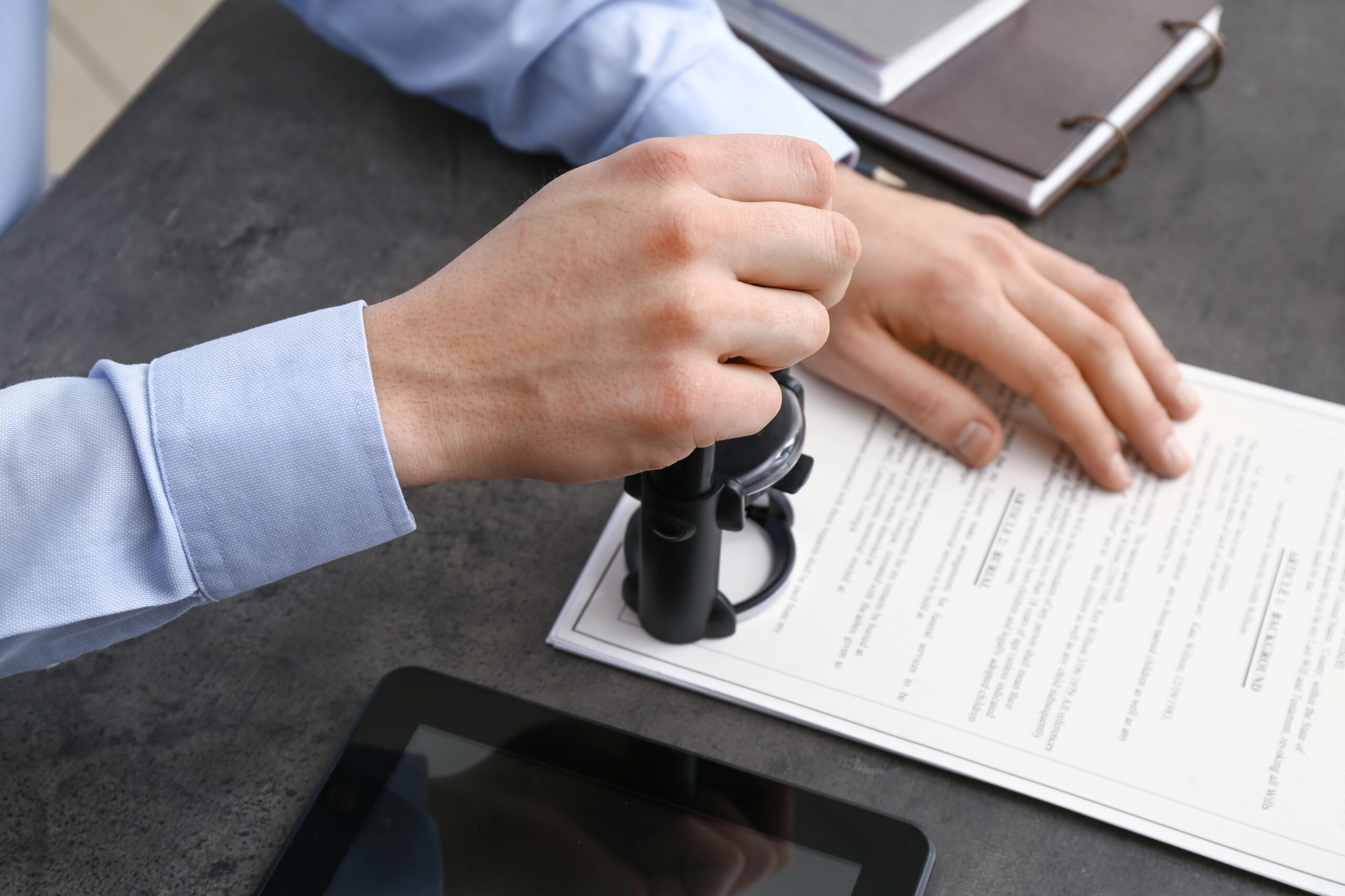 Male notary public placing official stamp on legal document in Warren County, NJ